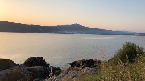 Scenic view of lake against clear sky during sunset