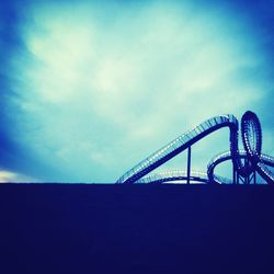 Low angle view of electricity pylon against blue sky
