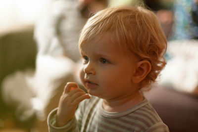 Cute baby boy looking away at home