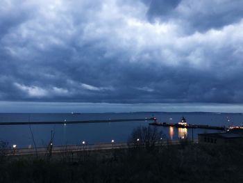 Scenic view of sea against cloudy sky at dusk