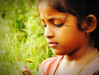 Close-up of cute girl smelling flower