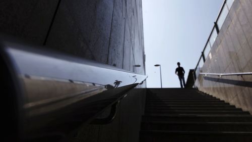Man standing on staircase against sky