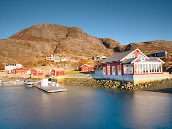 Scenic view of buildings and mountains against clear blue sky