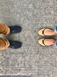 Low section of couple standing on concrete