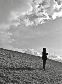 Full length of woman standing on field against sky