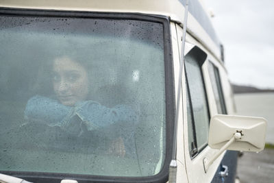 Portrait of teenage girl behind wheel of vintage van