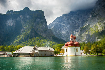 St bartholomew church by lake against mountain