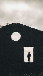 Rear view of woman walking on road against sky