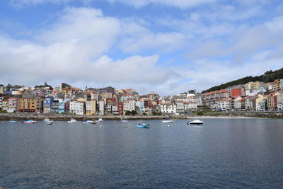 View of townscape by sea against sky