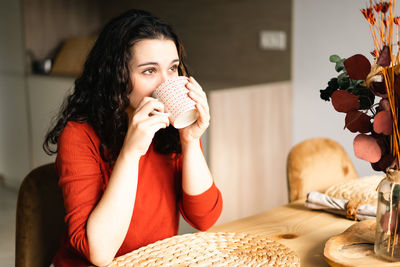 Young woman drinking coffee at home