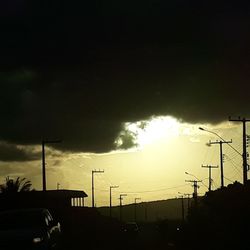 Cars on street against sky at sunset