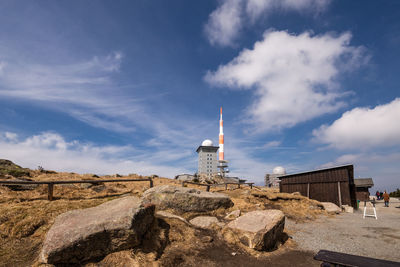 Lighthouse amidst buildings against sky