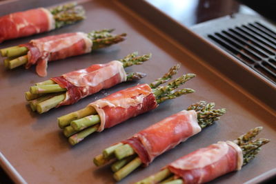 Close-up of asparagus with prosciutto in tray