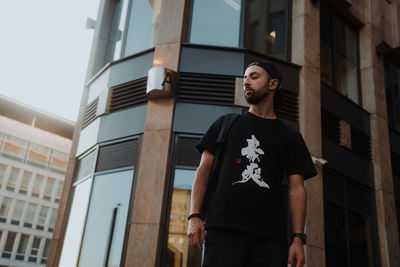 Young man standing against building