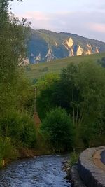 Scenic view of river by mountains against sky