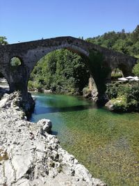 Arch bridge over river against sky