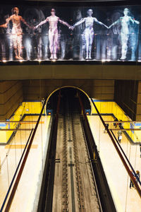 Posters over railroad tracks at subway station