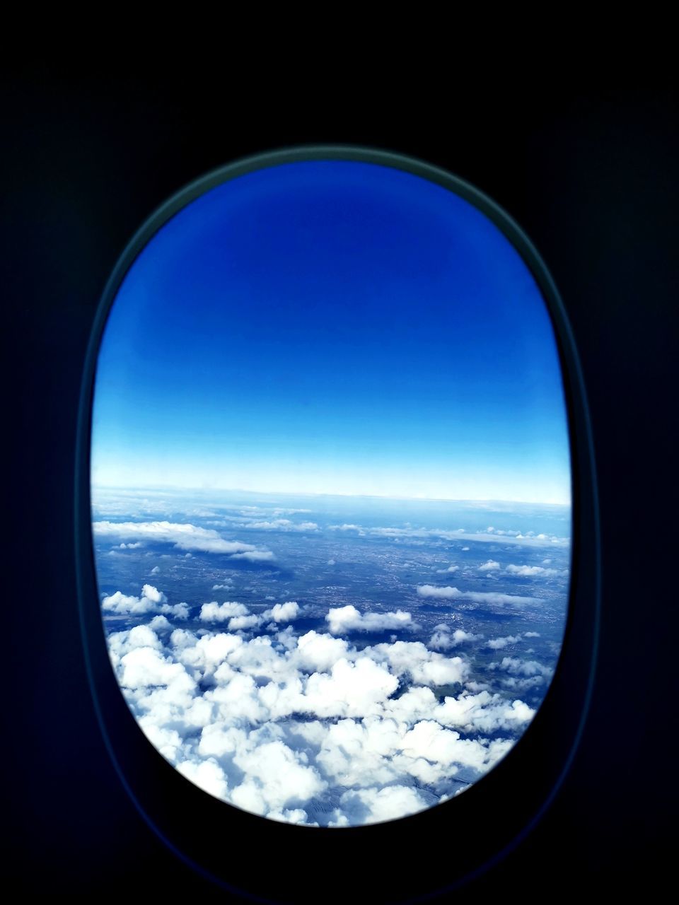 sky, blue, cloud, window, earth, airplane, reflection, nature, air vehicle, scenics - nature, aerial view, no people, travel, flying, beauty in nature, planet, horizon, transportation, environment, glass, outdoors, cloudscape, outer space, snow, light, mode of transportation, cold temperature, copy space, urban skyline, geometric shape, atmosphere, winter, landscape, space, day