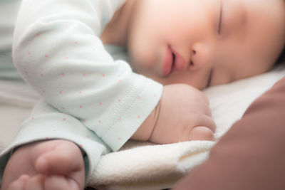 Close-up of baby sleeping on bed