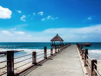 Pier over sea against blue sky