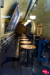 Empty chairs and tables in illuminated restaurant