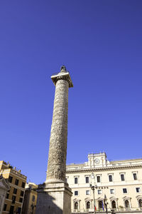 Colonna di marco aurelio and palazzo chigi against a clear blue sky - rome, italy