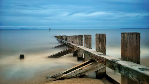 Wooden pier on sea against sky