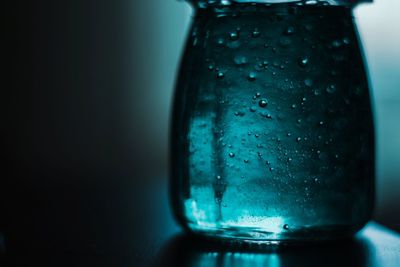 Close-up of wet glass against blue background