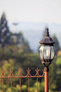 Street light by railing against sky