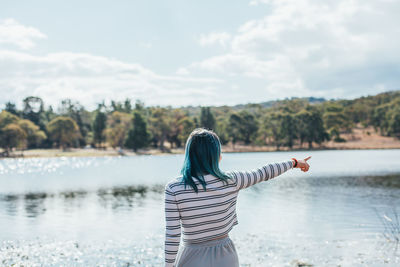 Rear view of woman standing in water against sky