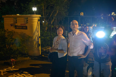 Full length portrait of friends standing at night