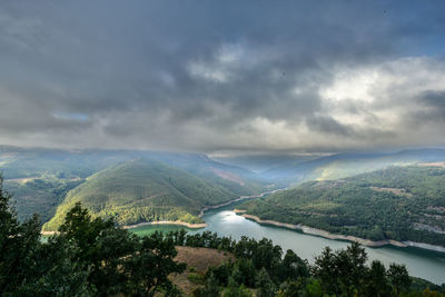 Scenic view of river amidst mountains against sky