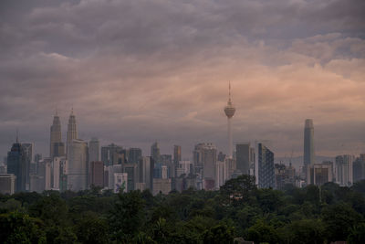 Modern buildings in city against cloudy sky