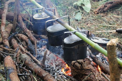 Close-up of containers over bonfire on field