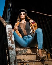 Low angle portrait of young woman sitting on steps