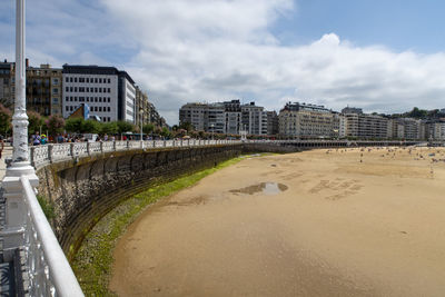 Road by beach against sky in city