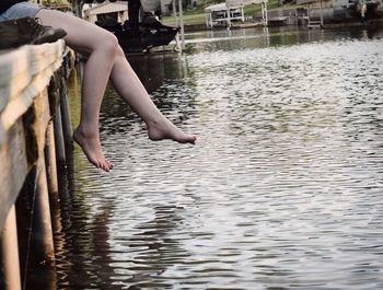 Low section of woman sitting in lake