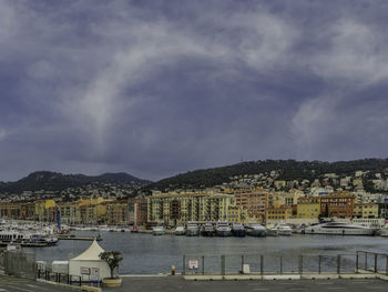 Townscape by river against sky in city