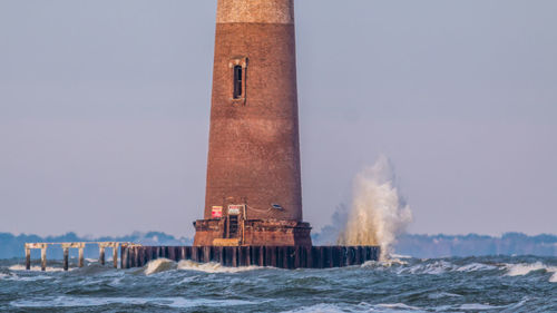 Close-up view of lighthouse and waves hitting platform base