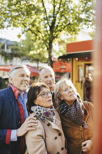 Male and female senior friends outside musical theater