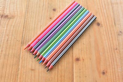 High angle view of multi colored pencils over white background