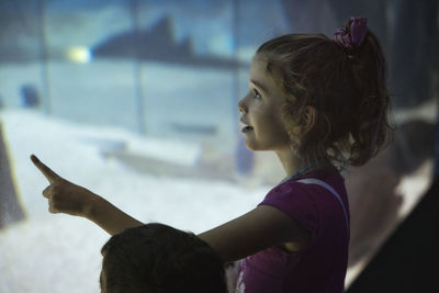 Side view of woman looking at aquarium