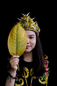 Portrait of young woman holding christmas tree