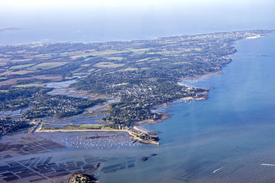 Aerial view of city by sea against sky