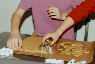 Two girls bake cookies at a table in the kitchen.