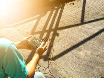 High angle view of woman photographing mobile phone outdoors