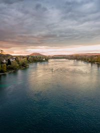 Scenic view of river against sky at sunset