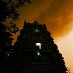 Low angle view of illuminated buildings against sky at night
