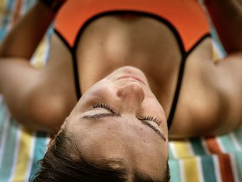 Close-up portrait of woman lying outdoors at beach 