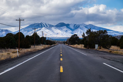 Road leading towards mountains against sky